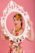 Portrait pinup avec cadre sur fond rose en studio.